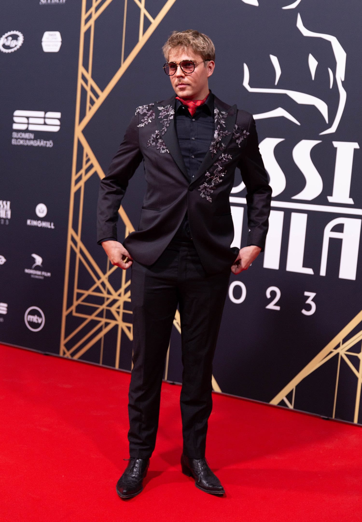 Aku Sipolan pukuun oli yhdistetty runsaasti kukkia. Näyttelijä luotti myös näyttäviin aurinkolaseihin tullessaan punaiselle matolle.