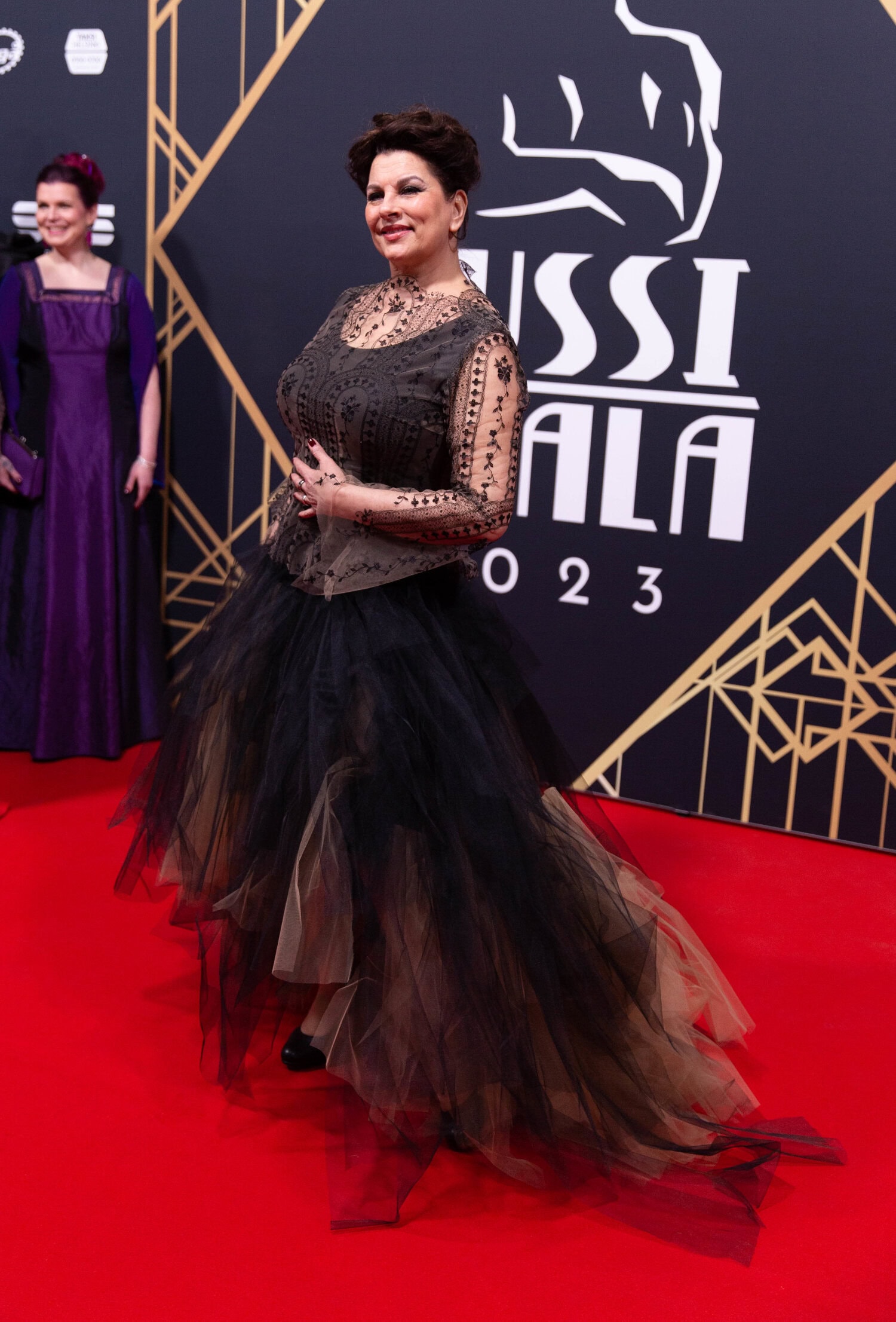 Satu Silvo luotti ruskeaan röyhelömekkoon, jonka yläosa oli kauniisti kirjailtu.