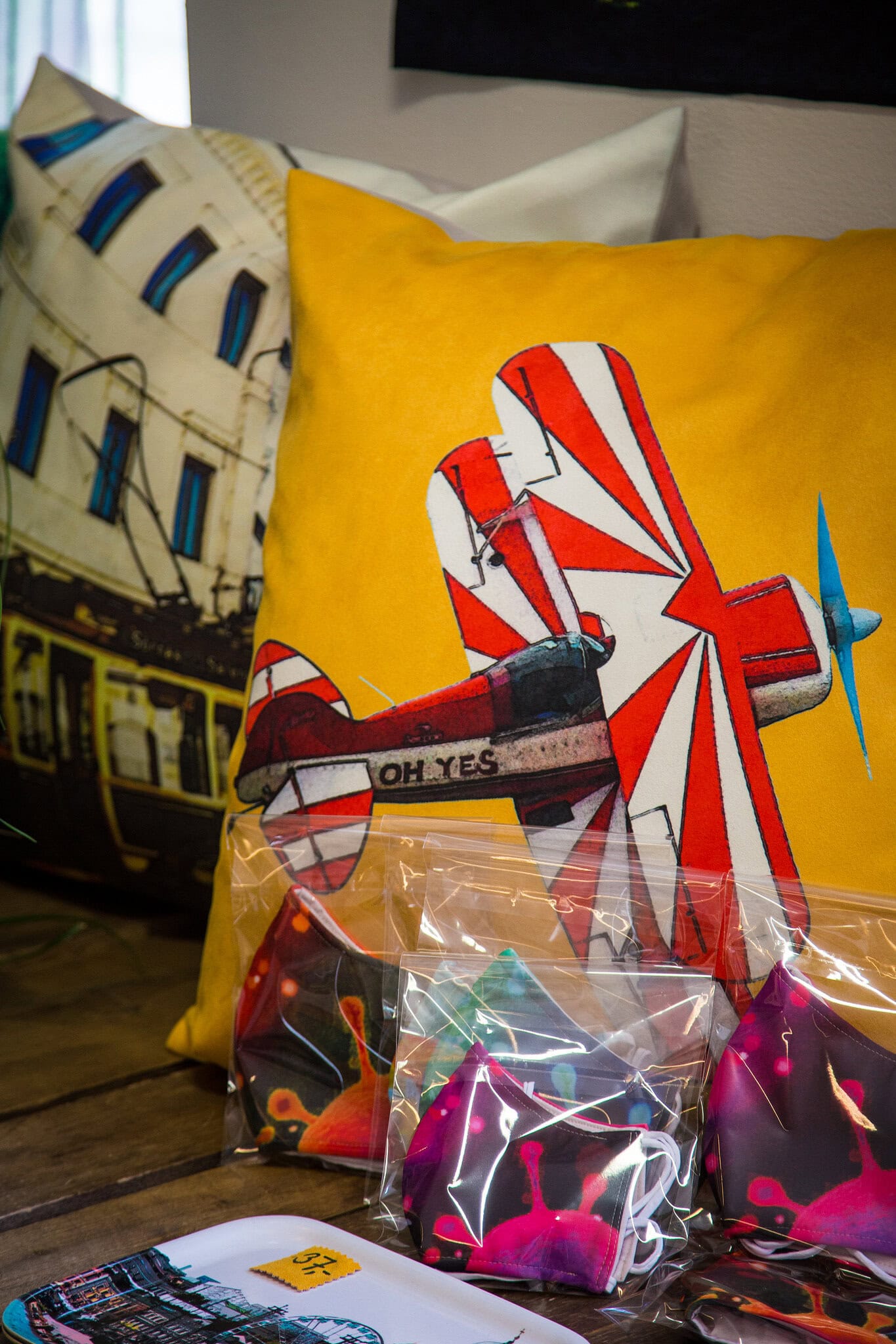 Malmin lentokentän tilanne inspiroi Juttaa. - Seurasin tilannetta ja päätin suunnitella Malmi-aiheisen kuosin. Lopulta syntyi kymmeniä ilmailuaiheisia tuotteita. Minusta Helsinkiin mahtuu yksi citykenttä. Se oli tavallaan poliittinen kannanotto, sanoo Jutta. Kuvassa myös virus-kuosisia kasvomaskeja.