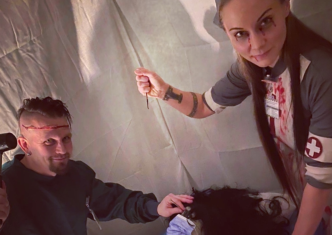 Heikki ja hänen vaimonsa Elina halloween-juhlissa koristenuken vierellä.